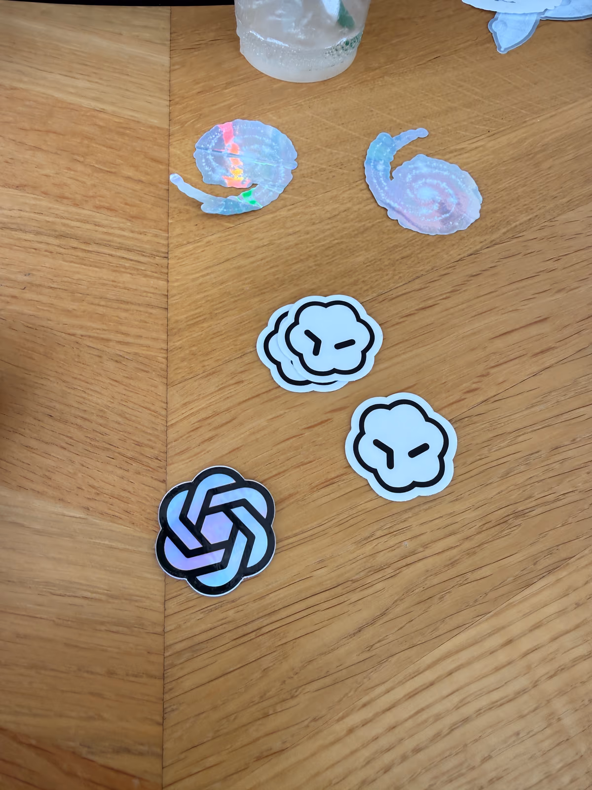 AI company stickers scattered on a wooden table